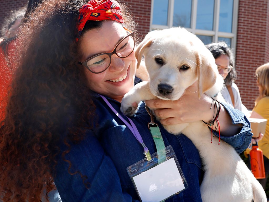 Clavel Rangel, a Venezuelan journalist and senior editor of El Tiempo Latino, holds a rescue puppy that was brought in to help attendees decompress on a lunch break. Photo: Kat Duncan