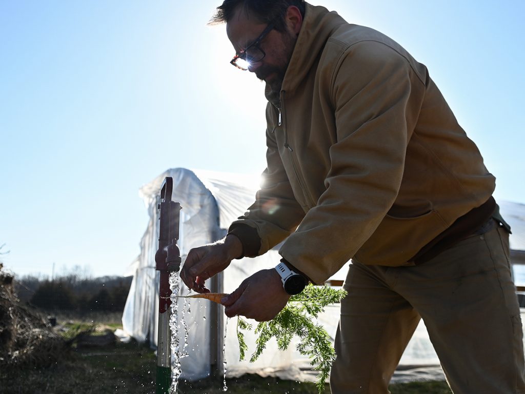  Matt Arthur, the owner of Booneslick Heritage Farm in Midway, Mo., picks a carrot for his daughter. The family-owned flower and vegetable farm in Mid-Missouri uses several regenerative agriculture practices to improve soil health and reduce fertilizer use. Missouri School of Journalism student Maya Bell did a photo story on the farm as part of “The Price of Plenty,” an investigation of the fertilizer industry for the Ag & Water Desk. Photo: Maya Bell | Mississippi River Basin Ag & Water Desk