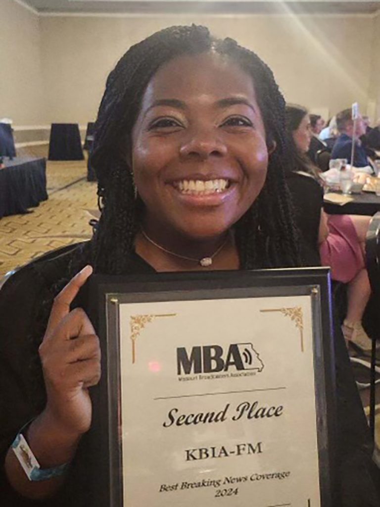 KBIA Managing Editor Katelynn McIlwain displays the second-place plague KBIA was awarded for Best Breaking News Coverage.