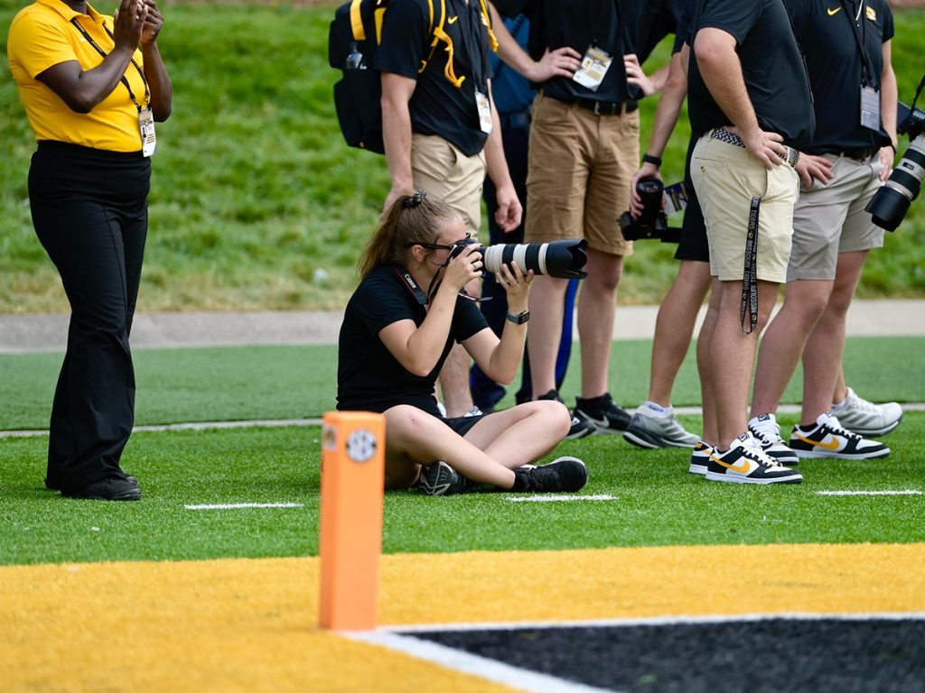 Taylor Holmes, seated, takes photos from the north end zone during the Mizzou vs. Boston College football game on Sept. 14, 2024, on Faurot Field.