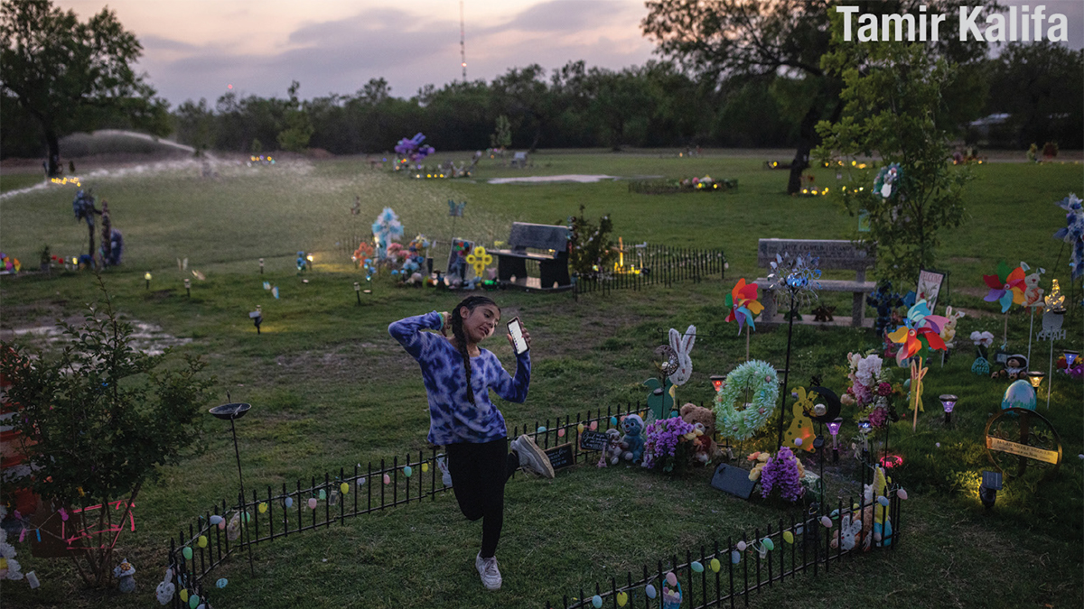 Photo of a little girl taking a selfie in a decorated graveyard by Tamir Kalifa.