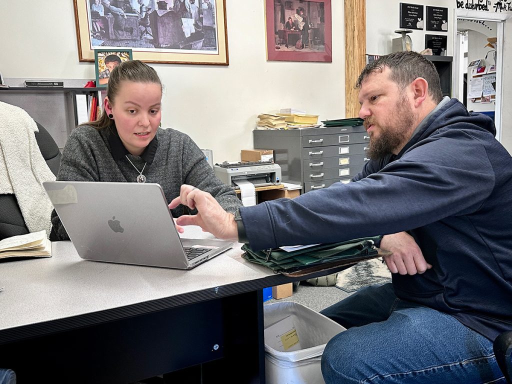 Genevieve Smith, left, explains her upgrades to Trevor Vernon’s newsletters on Jan. 16, 2025, at The Advertiser in Eldon, Missouri. Vernon, right, publishes six newspapers in the Lake of the Ozarks region of the state.