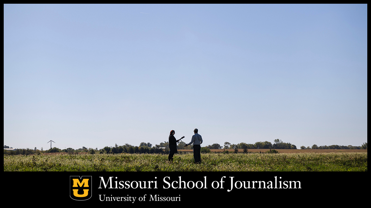Jana Rose Schleis interviews a farmer out in a field