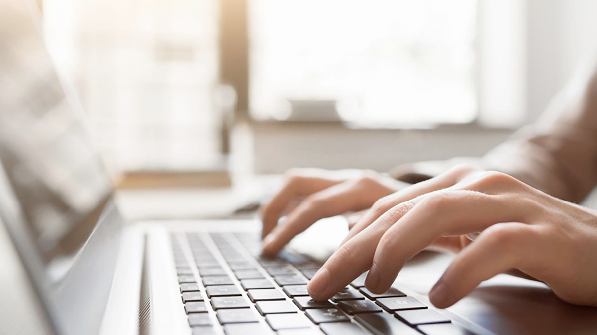 Hands on a laptop keyboard
