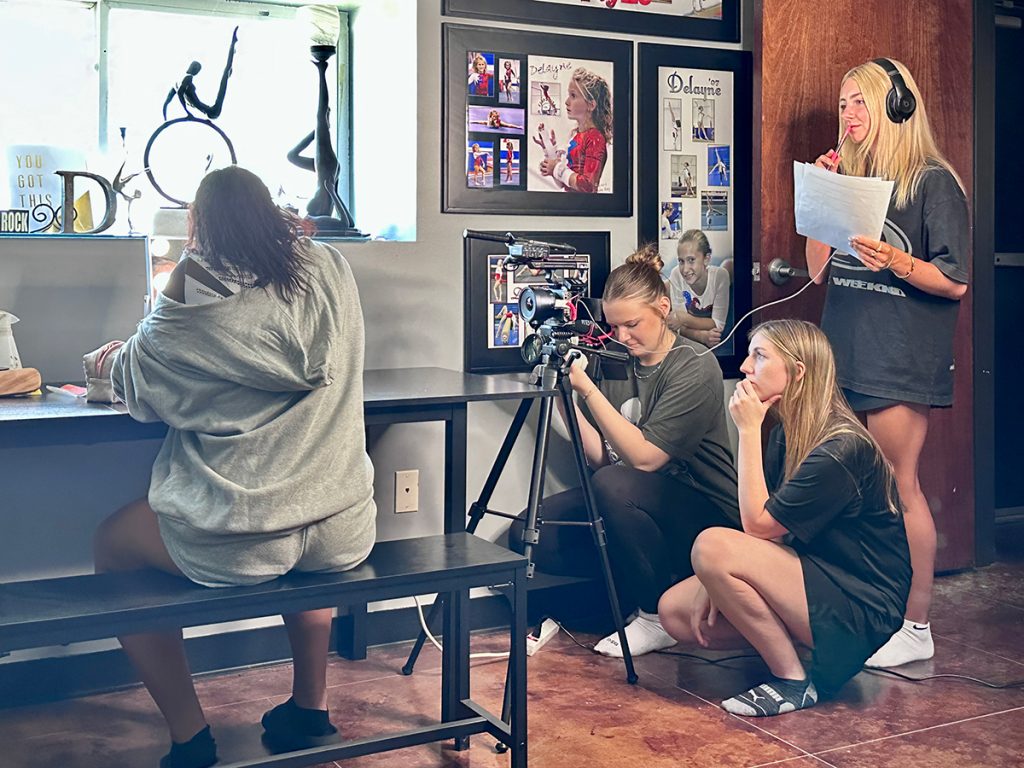 Morgan, far right, was the creative producer for a Scarlett Creative project featuring Mizzou gymnast Kennedy Griffin, seated, at Flipz Gymnastics in Columbia, Missouri. Morgan, who is interviewing Griffin, is listening to the gymnast’s responses captured by Katie Dalton’s tripod-mounted camera. Junior Carys Shelley, meanwhile, is capturing video with a hand-held camera. Photo: Nate Brown