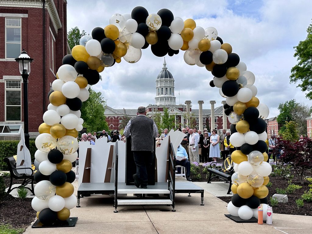 An arch of black and gold balloons frames Joe Kovalyan, Director of Landscape Services at Mizzou, as he addresses the crowd at the Heflin Memorial Garden dedication ceremony.
