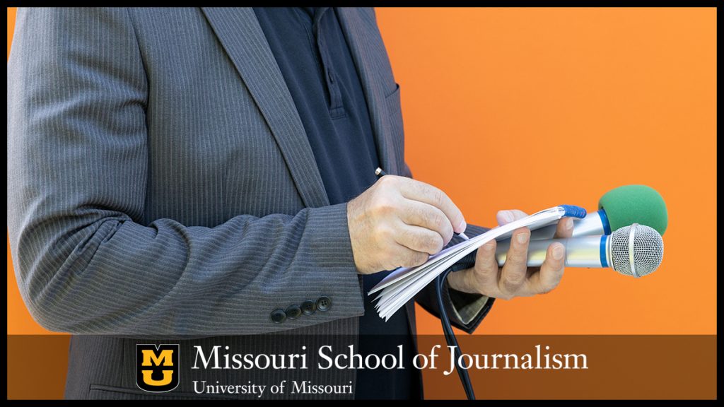 Reporter taking notes holding two microphones