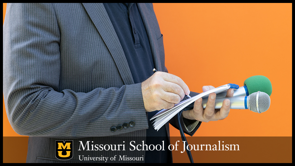 Reporter taking notes holding two microphones